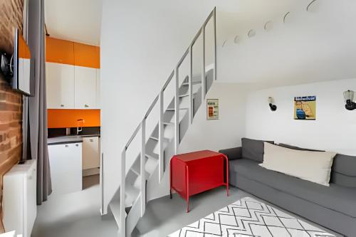 un salon avec un escalier et une table rouge dans l'établissement Casa Naranja, à Paris