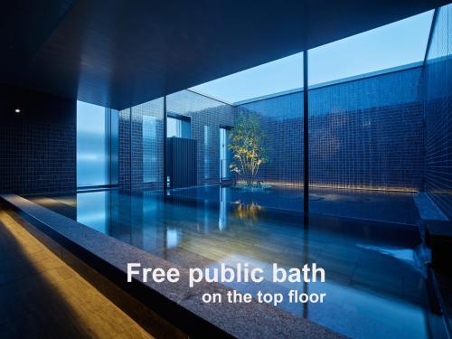 a view of a building with the words free public bath on the top floor at Mitsui Garden Hotel Fukuoka Nakasu in Fukuoka