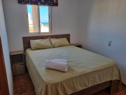 ein Schlafzimmer mit einem Bett und einem Handtuch darauf in der Unterkunft Torete in Roquetas de Mar