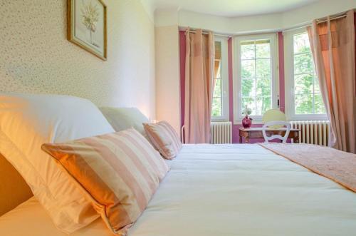 a bedroom with a large white bed and a window at La demeure du lac d'orient in Montieramey