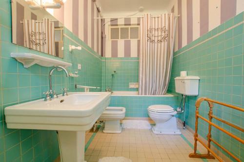 a blue bathroom with a sink and a toilet at La demeure du lac d'orient in Montieramey
