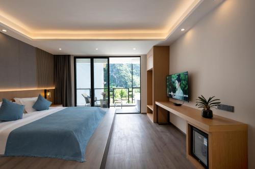 a bedroom with a large bed and a tv at Yangshuo-Greenery Retreat in Yangshuo