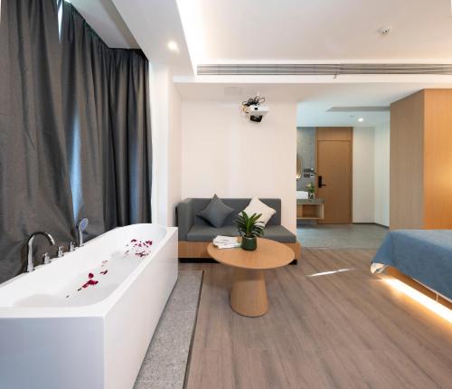 a living room with a bath tub and a couch at Yangshuo-Greenery Retreat in Yangshuo