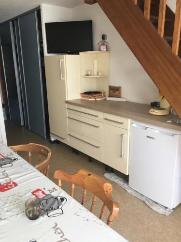 Il comprend une cuisine équipée d'un réfrigérateur et d'une table avec des chaises. dans l'établissement Pyrène, à Vielle-Aure