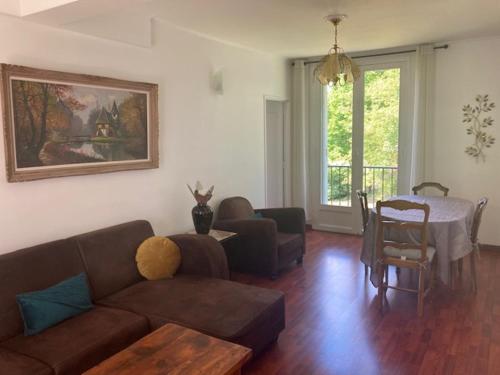 un salon avec un canapé et une table dans l'établissement Appartement au calme pour 4 - résidence arborée - Proche Paris 20 min, à Draveil