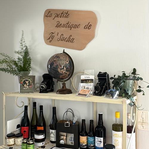 - une étagère avec des bouteilles de vin et un panneau dans l'établissement Aux portes de Pornichet, Chambres d'hôtes Ty'Sacha, à Saint-Nazaire