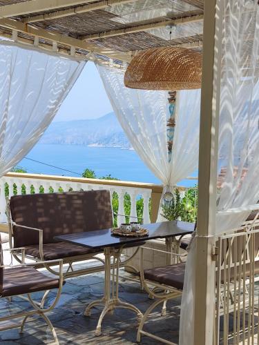 a table and chairs on a balcony with a view of the ocean at Villa IRENE in Zóla
