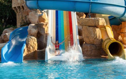 a woman is jumping off a water slide at a water park at Marhaba Salem - Family Only in Sousse