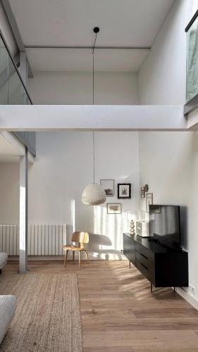 a living room with a tv and a couch and a table at Luxury spacious private loft, between city & beach in Heemstede
