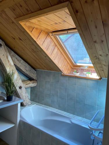La salle de bains mansardée est pourvue d'une grande baignoire. dans l'établissement Superbe duplex cosy au cœur de Mônetier Les Bains, au Monêtier-les-Bains