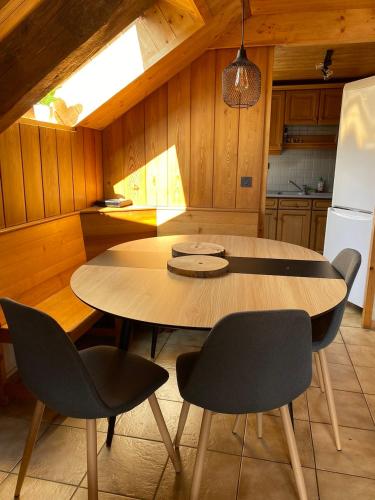 une cuisine avec une table et des chaises dans une cuisine dans l'établissement Superbe duplex cosy au cœur de Mônetier Les Bains, au Monêtier-les-Bains