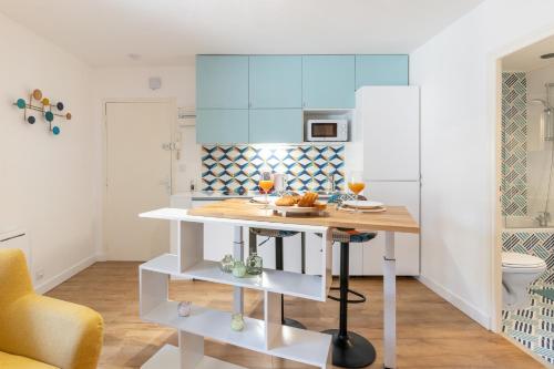 une cuisine avec des armoires bleues et une table dans l'établissement NEW OPEN - Le secret - Netflix - Centre ville, à Nantes