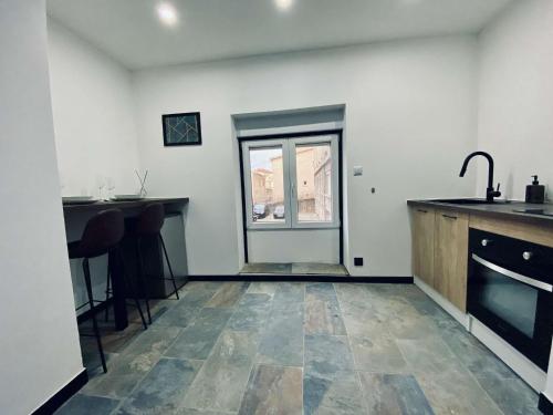 une cuisine avec un comptoir, un évier et une fenêtre dans l'établissement nuit d exception avec jacuzzi, à Bourg-de-Péage