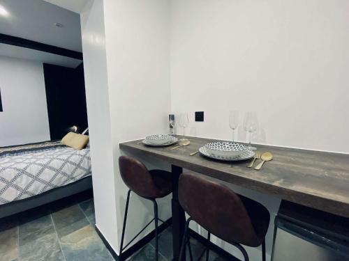 a room with a counter with chairs and a bed at nuit d exception avec jacuzzi in Bourg-de-Péage