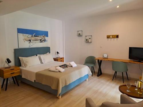ミクロス・ギアロスにあるIlianthos Apartments & Roomsのベッドとパソコン付きの机がある寝室