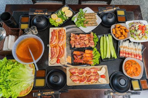a table topped with different types of food and drinks at Sunrise Hanoi Hotel in Hanoi