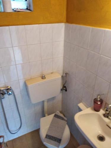 a small bathroom with a toilet and a sink at LittleParadise100MFromTheBeach in Áyioi Apóstoloi