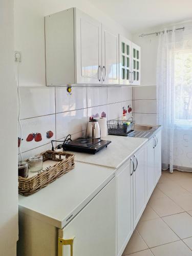 a kitchen with white cabinets and a counter top at Apartman Radulovic in Negotin