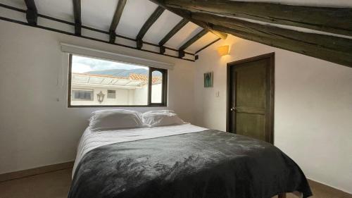 a bedroom with a large bed with a window at Hotel Verona Villa de Leyva in Villa de Leyva