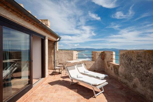 a pair of white lounge chairs on the balcony of a house at Torre Mozza - Dimora d' Epoca in Follonica