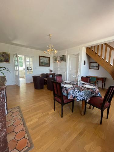un salon avec une table et des chaises et un escalier dans l'établissement Le Bassin, à Honfleur