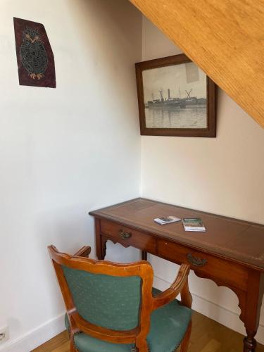 - un bureau avec une chaise à côté d'une table avec une photo dans l'établissement Le Bassin, à Honfleur