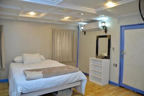 a bedroom with a bed with a mirror and a dresser at Cinderella Malika in Al Bayāḑīyah