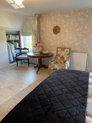 a bedroom with a bed and a table and chairs at "Het Steechje" in Ie bij Schiermonnikoog en Ameland in Ee