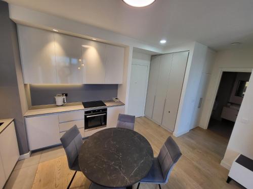 a kitchen with a table and chairs in a room at BW Waterfront LUX apartment, parking free in Sajmište