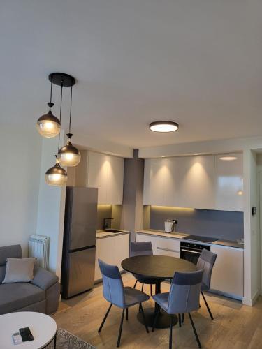 a kitchen and a living room with a table and chairs at BW Waterfront LUX apartment, parking free in Sajmište
