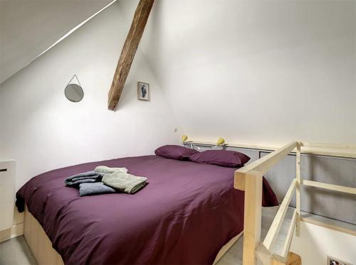 - une chambre dotée d'un lit avec des draps violets dans l'établissement Chez Mily Joli petit duplex plein centre Villers Cotteret draps et serviettes fournis, à Villers-Cotterêts