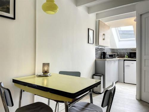 une cuisine et une salle à manger avec une table et des chaises dans l'établissement Chez Mily Joli petit duplex plein centre Villers Cotteret draps et serviettes fournis, à Villers-Cotterêts