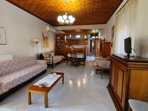 a living room with a couch and a table at MetaxiasAndMariasHouse in Leonidion