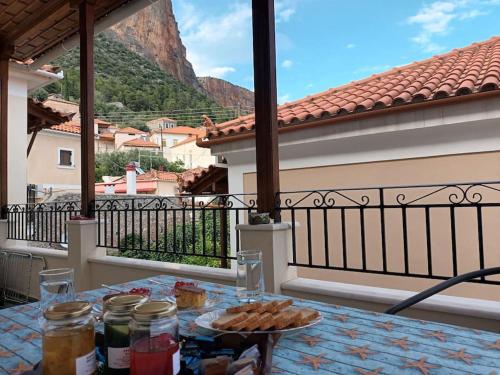 a table with a plate of food on a balcony at MetaxiasAndMariasHouse in Leonidion
