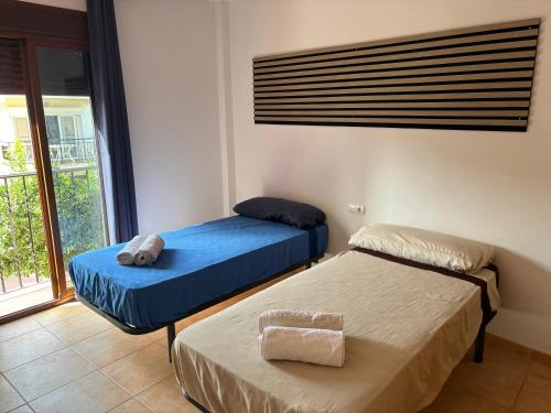 two beds in a room with a window at Habitación en Casa Vacacional Fuengirola in Fuengirola