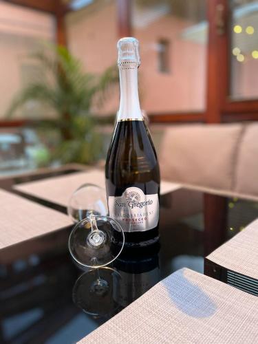 a bottle of wine sitting on a table with two glasses at Apartmány Kašper in Levoča