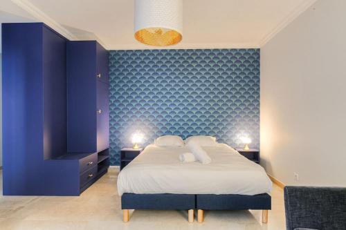 - une chambre avec des murs bleus et un lit avec deux lampes dans l'établissement Appartement fonctionnel et bien situé, coeur 6ème, à Lyon