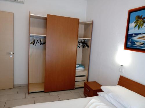 a bedroom with a wooden closet and a bed at Residence VAPORE in Gatteo a Mare