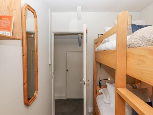 a small room with bunk beds and a mirror at Hole Farm Stables in Newton Abbot