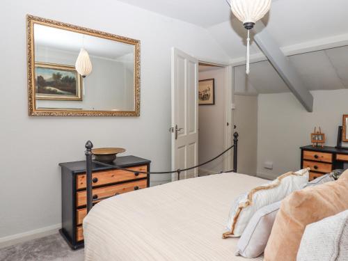 a bedroom with a bed and a mirror at Hole Farm Stables in Newton Abbot