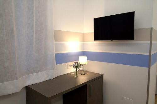 a room with a television and a table with a lamp at Giuliani Rooms in Ancona