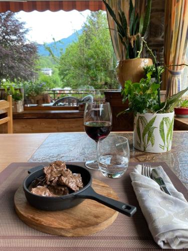 a table with a plate of food and a glass of wine at Hotel della valle in Vernante