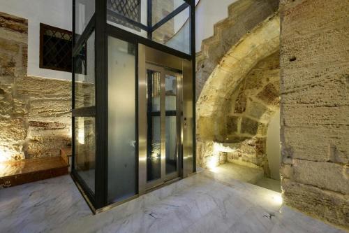 una porta di vetro in una stanza con parete in pietra di Attico Sesto Canto a Palermo