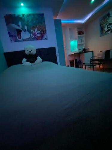 - un ours en peluche assis sur un lit dans une pièce dans l'établissement Sultan Spa Privatif Lille, à Lille