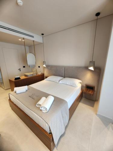 a bedroom with a large bed with two towels on it at Hotel Summer Dream in Dhërmi