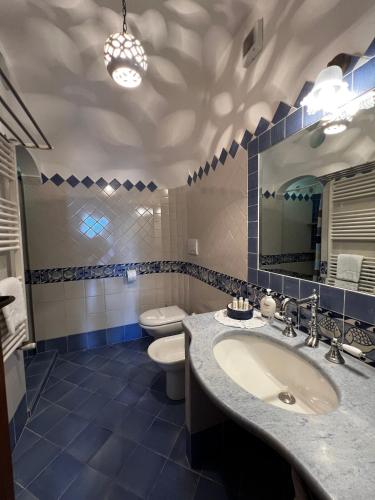 a bathroom with a sink and a toilet and a mirror at Casa Angelica Positano in Positano