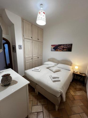 a white bedroom with a bed and a white cabinet at Casa Angelica Positano in Positano