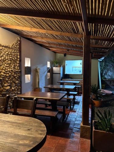 a restaurant with wooden tables and benches and a tv at Casa Ande Hotel boutique in Villa de Leyva