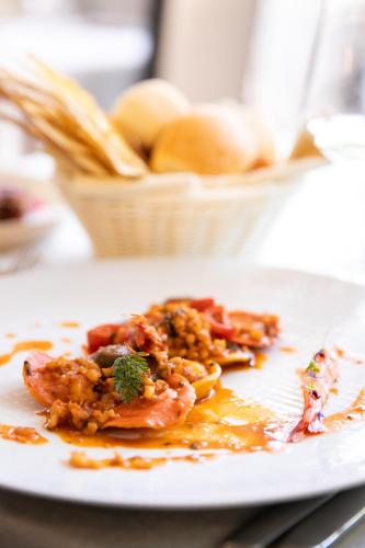 a white plate with food on a table at Mannu Hotel in Bosa