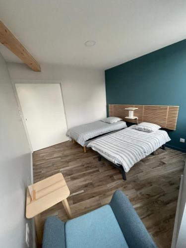 a room with two beds and a blue couch at Appart du faubourg in Valence